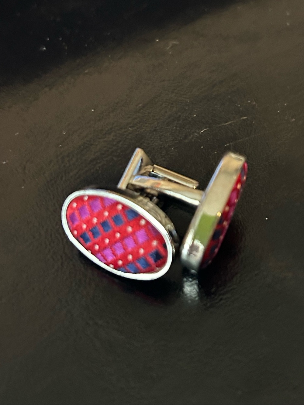 Thomas Pink chrome colored cufflinks with a red silk pattern.  Unisex.